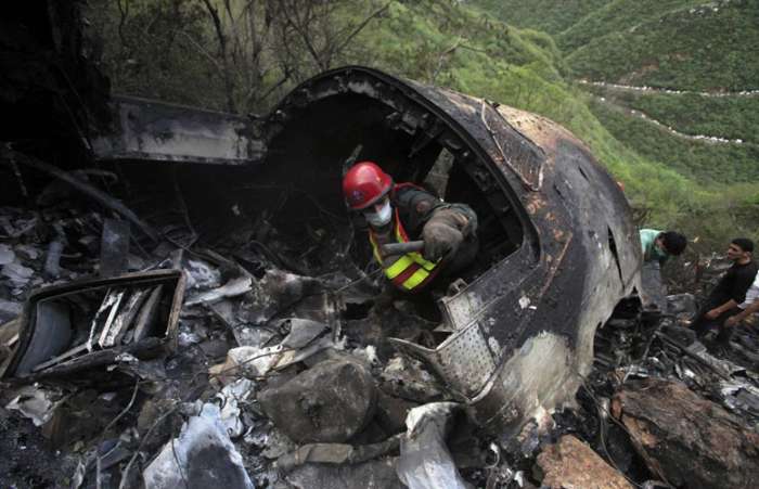 Bombeiro vasculha escombros do Airbus que caiu no Paquistão