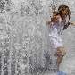 Criança se refresca em fonte na cidade de Budapeste, na Hungria. Termômetros atingiram 40°C