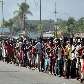 Haitianos fazem fila para receber alimentos do Exército brasileiro