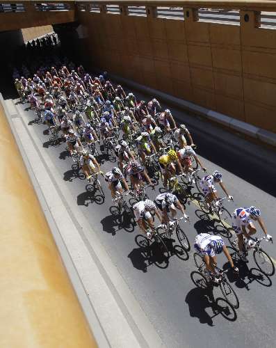 Pelotão de ciclistas passa por túnel no quinto estágio da Volta da França