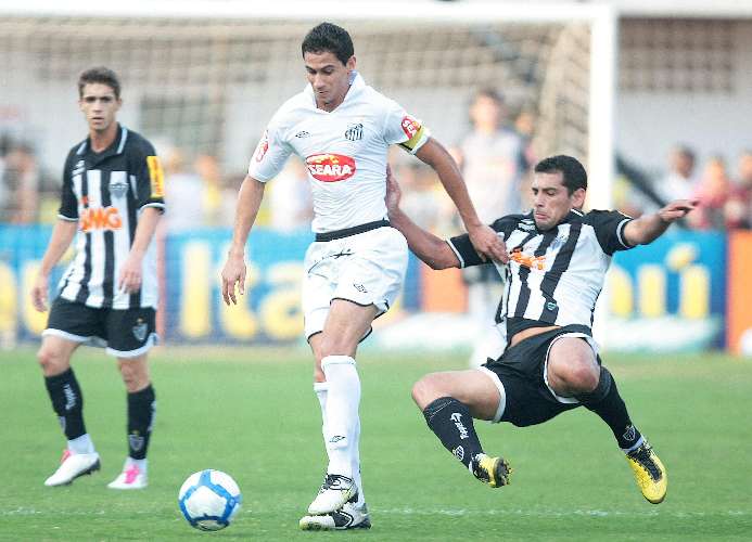 O meio-campo Ganso, do Santos, domina a bola antes de carrinho de Diego Souza, do Atlético-MG