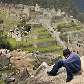 Turista descansa em uma pedra nas ruínas da cidadela Turista descansa em uma pedra nas ruínas da cidadela