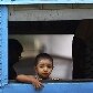 Menino de Mianmar observa através da janela de um trem na Estação Central de Yangon Menino de Mianmar observa através da janela de um trem na Estação Central de Yangon