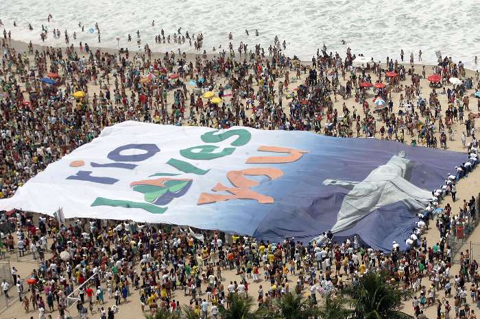 Bandeira gigante com imagem do Cristo Redentor é estendida no Rio