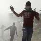 Protestantes palestinos e estrangeiros correm da polícia após protesto conta a barreira no West Bank Protestantes palestinos e estrangeiros correm da polícia após protesto conta a barreira no West Bank