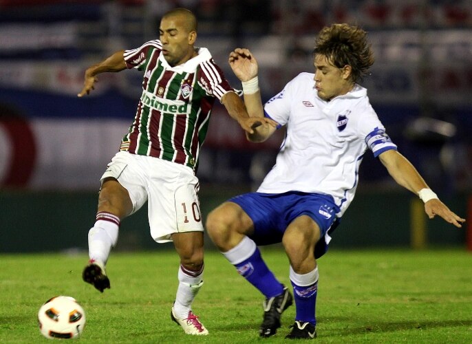 Emerson, do Fluminense, disputa a bola com Iván Coates, do Nacional, que venceu por 2 a 0