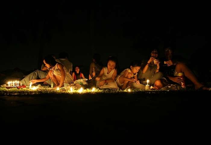 Pessoas acendem velas em parque de Cingapura durante a Hora do Planeta, neste sábado, 27