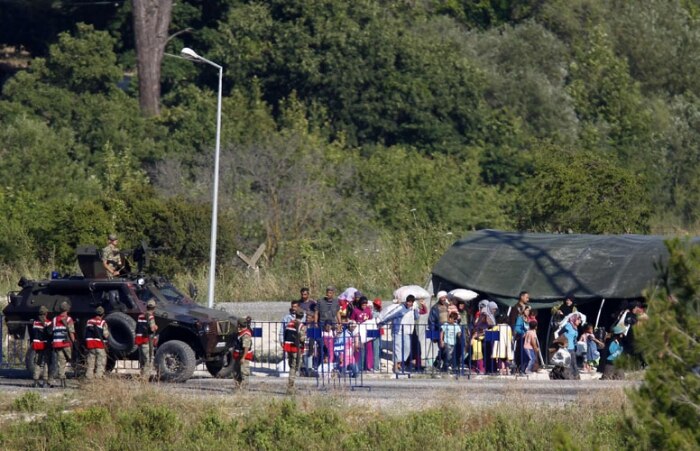 Sírios aguardam tranferência para campo de refugiados na Turquia 