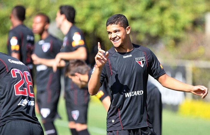 Luis Fabiano corre pelo campo, enquanto companheiros treinam com a bola no CT do São Paulo