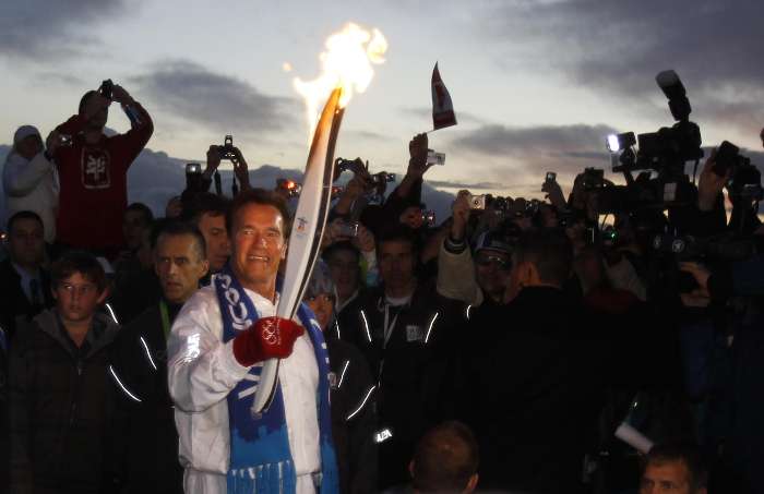 Arnold Schwarzenegger carrega a tocha olímpica no revezamento para os Jogos de Inverno