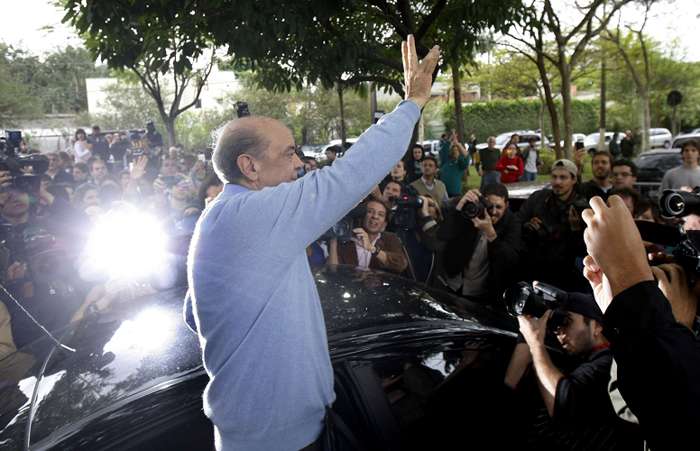 José Serra, candidato do PSDB à presidência, saúda os eleitores após votar no Colégio Santa Cruz, em