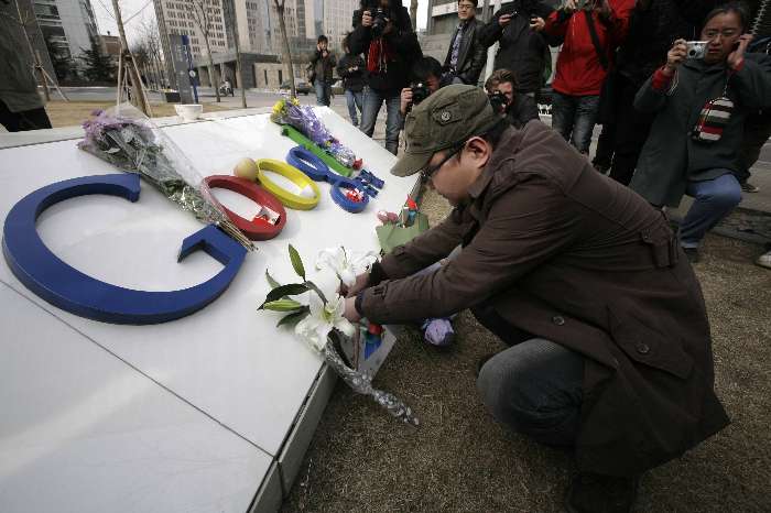 Homem coloca flores no logo do Google em Beijing, China