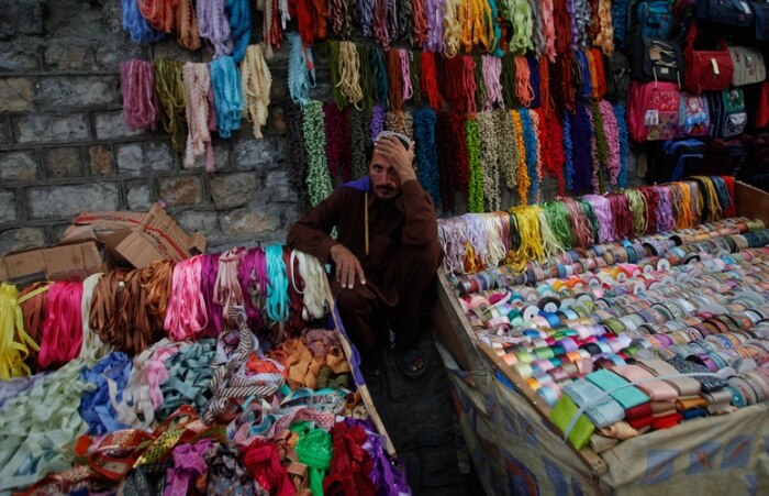 Homem vende fitas coloridas para fantasias em rua de Abbottabad, no Paquistão