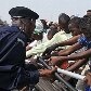 Policial tenta segurar multidão que quer assistir cerimônia militar da independência da Rep. Congo Policial tenta segurar multidão que quer assistir cerimônia militar da independência da Rep. Congo