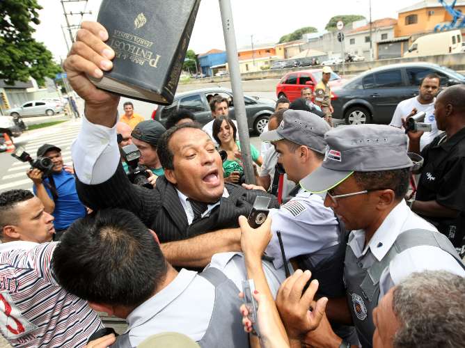 Evangélico é amparado pela PM após quase ser linchado pelas pessoas em frente ao fórum de Santana