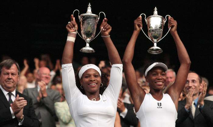 As irmãs Serena e Venus Williams erguem os troféus de campeãs de duplas em Wimbledon
