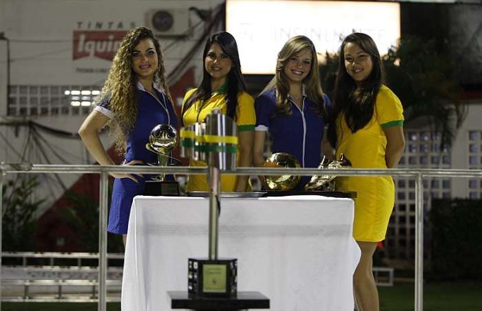 Modelos exibem o troféu e os prêmios da final da Copa do Brasil em Salvador, no Barradão
