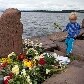 Criança coloca flor em monumento improvisado em memória aos ataques ocorridos em Oslo na sexta-feira
