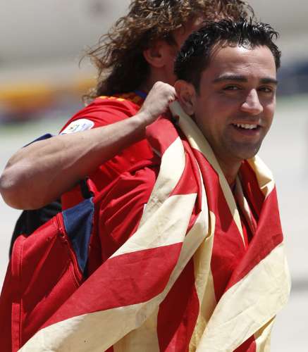 Xavi Hernandez, um dos destaques da Espanha, desembarca coberto com a bandeira do país
