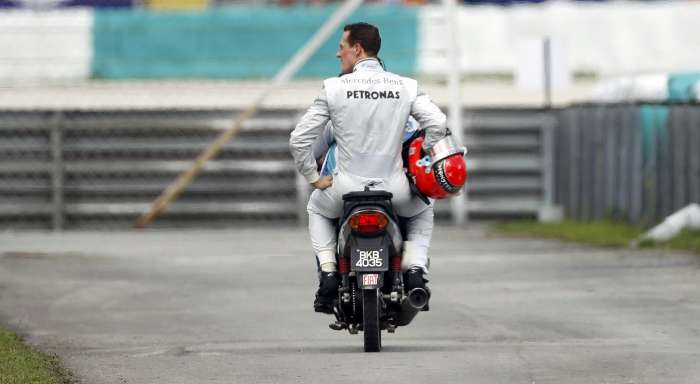 Michael Schumacher volta de carona para os boxes após abandonar o GP da Malásia por quebra