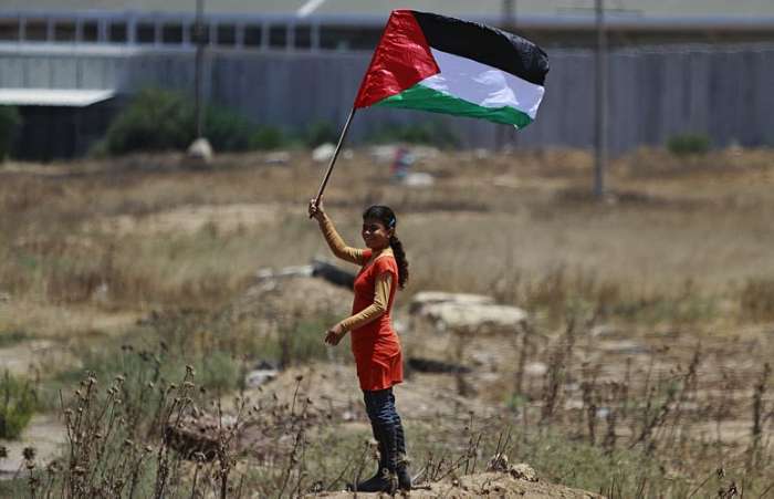 Em marcha semanal contra Israel, palestina flameja a bandeira de sua pátria na fronteira dos países