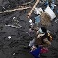 Mulher recolhe comida em meio aos descombros de mercado destruído pelo tsunami em Otsuchi