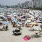 Turistas se divertem na praia neste verão Turistas se divertem na praia neste verão