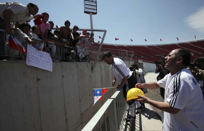 Mario Sepulveda e Juan Illanes dão autógrafos após a partida no Estádio Nacional de Santiago