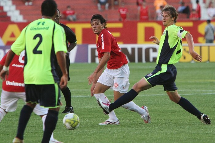 Ricardo Goulart, do Internacional, passa a bola entre a marcação do Porto Alegre na vitória por 1x0 