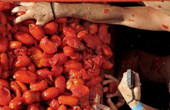A Tomatina é uma batalha em que as pessoas jogam tomates umas nas outras nas ruas de Buñol