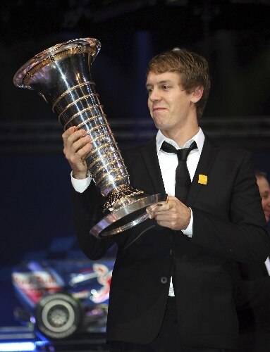 O alemão Sebastian Vettel admira o troféu de campeão mundial de Fórmula 1 em 2010, recebido da FIA