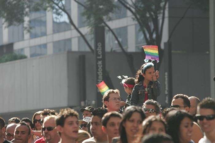 Menina observa participantes da Parada Gay