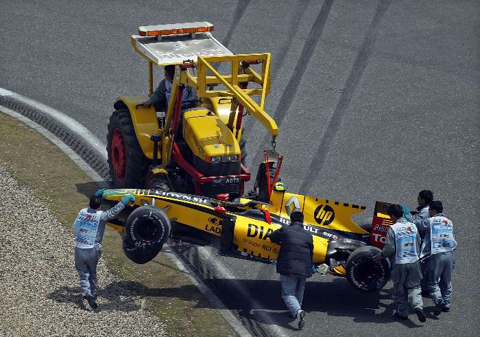 Renault do russo Vitlay Petrov é retirado da pista após bater no 3.º treino livre do GP da China