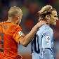O holandês Heitinga consola Forlan, do Uruguai, após desclassificação da seleção celeste