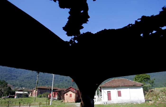Carcaça de trem enferrujada e casas abandonadas ao fundo; PAC pode ajudar a preservar o local