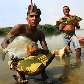 Índios da etnia Arara exibem peixes que foram pescados no Xingu, onde será construída a usina