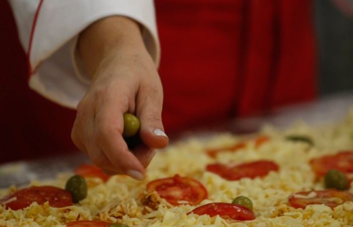 Pizzaiolo faz pizza gigante para celebrar o dia da iguaria 
