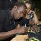 Usain Bolt autografa uma camiseta após entrevista coletiva na Jamaica