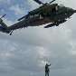 Membros da equipe de resgate descem do helicóptero através de corda para recolher objetos e corpos Membros da equipe de resgate descem do helicóptero através de corda para recolher objetos e corpos