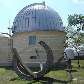 Relógio de sol ao lado de cúpula de observação no campus do Observatório Nacional