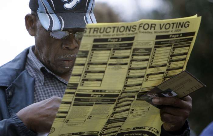 Um homem lê as instruções para votação enquanto aguarda sua vez na fila, na Carolina do Norte