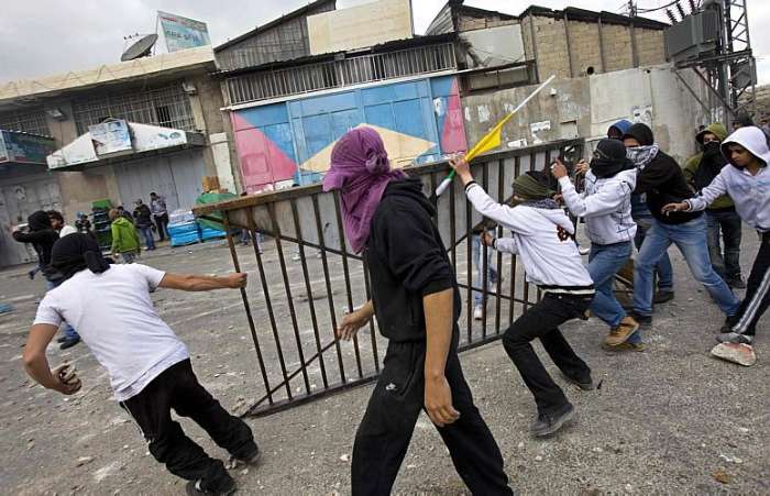 Palestinos tentam arremessar grade contra policiais