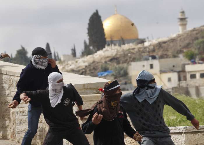 Protestantes palestinos jogam pedras contra tropas israelitas