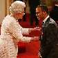 A rainha Elizabeth II entrega a Lewis Hamilton uma medalha