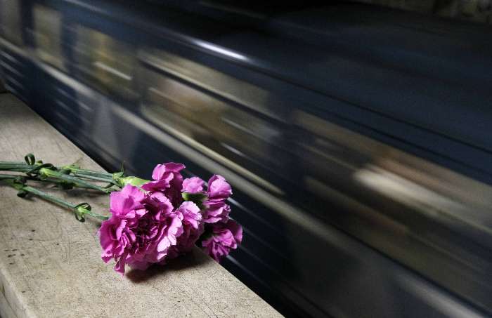 Trem passa por flores deixadas em memória das 37 vítimas pela explosão de bombas no metrô de Moscou