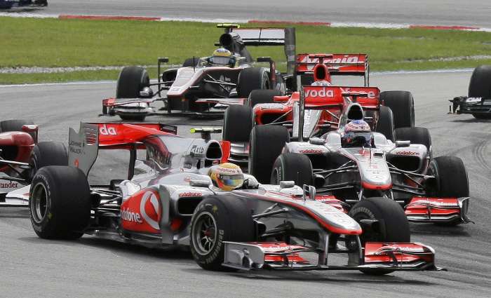 Lewis Hamilton e Jenson Button chegam juntos na curva após a largada do GP da Malásia de F-1
