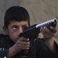 Meninos brincam com armas de brinquedo em uma cena de batalha em Cabul, no Afeganistão Meninos brincam com armas de brinquedo em uma cena de batalha em Cabul, no Afeganistão