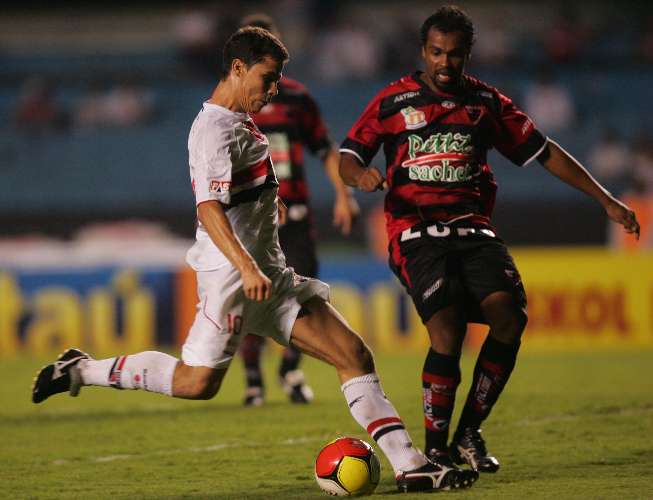 Hernanes, do São Paulo, tenta chutar antes de Luciano Santos, do Oeste