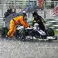 Mecânicos empurram a Williams de Kazuki Nakajima sob chuva, na Malásia