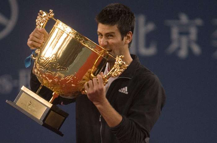 Novak Djokovic morde a taça após conquistar o Torneio de Pequim